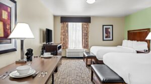 Hotel room with 2 beds, dining table, TV and window