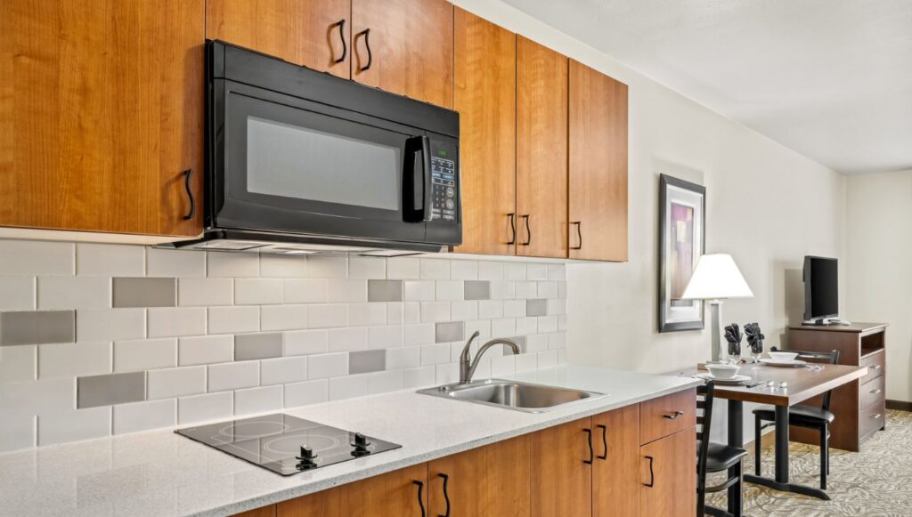Ledgestone Hotel Vernal - Kitchen with microwave and 2 burner stove with dining table and TV